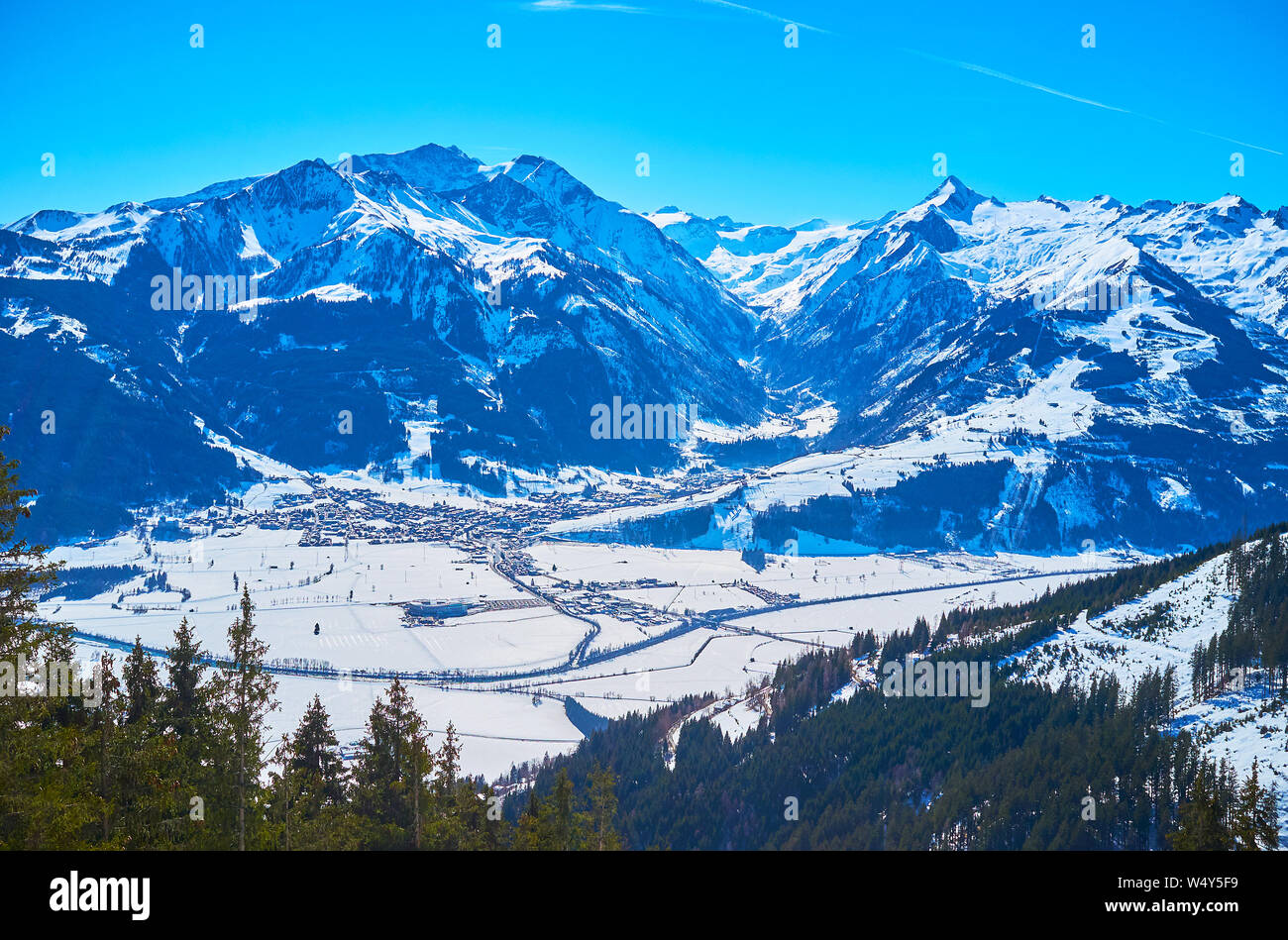 Enjoy aerial panorama of Kaprun, located in snowy valley at the foot of huge Kitzsteinhorn mountain, Austria Stock Photo