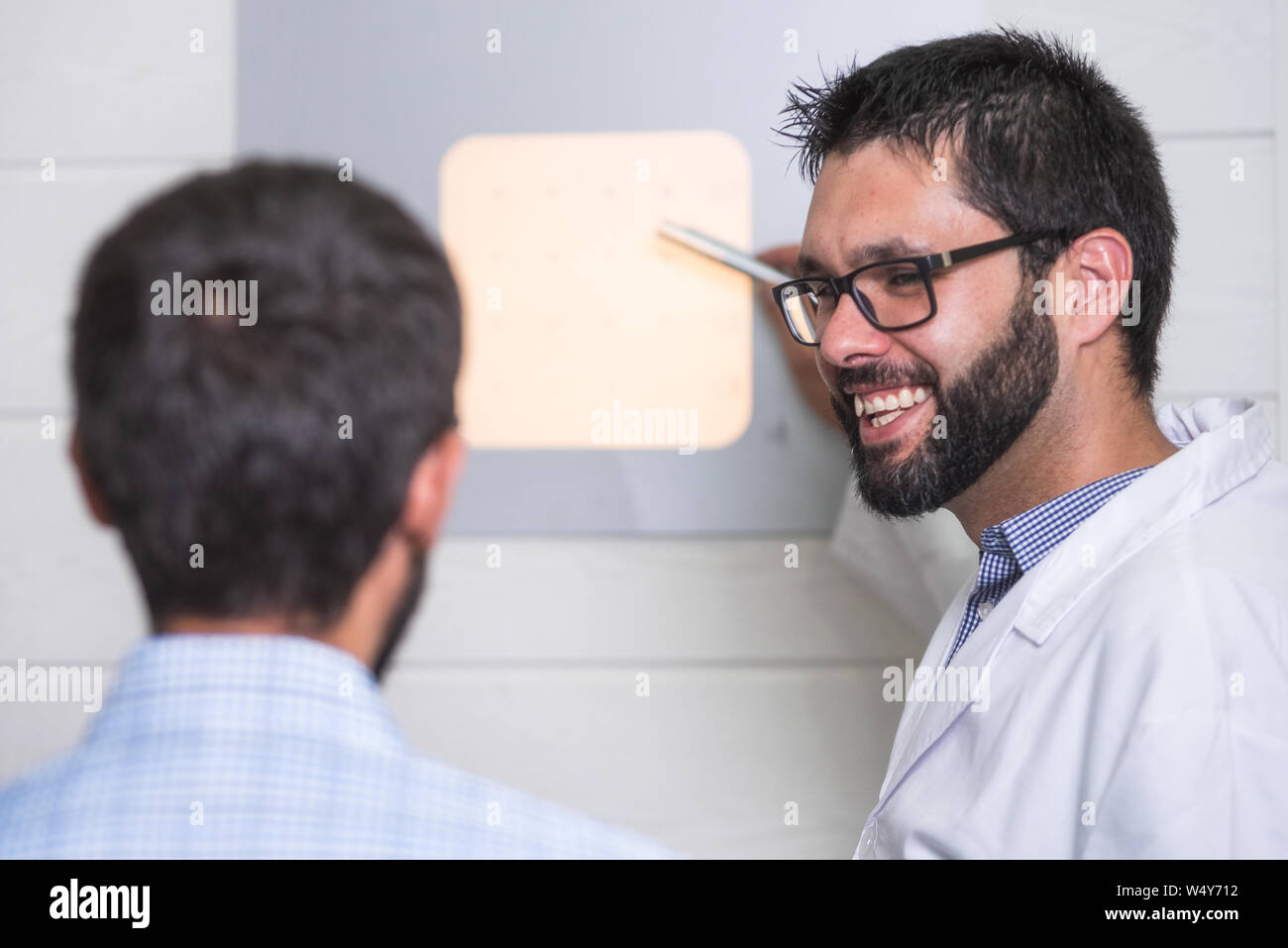 Ophthalmologist pointing at letters while patient is reading the eye ...