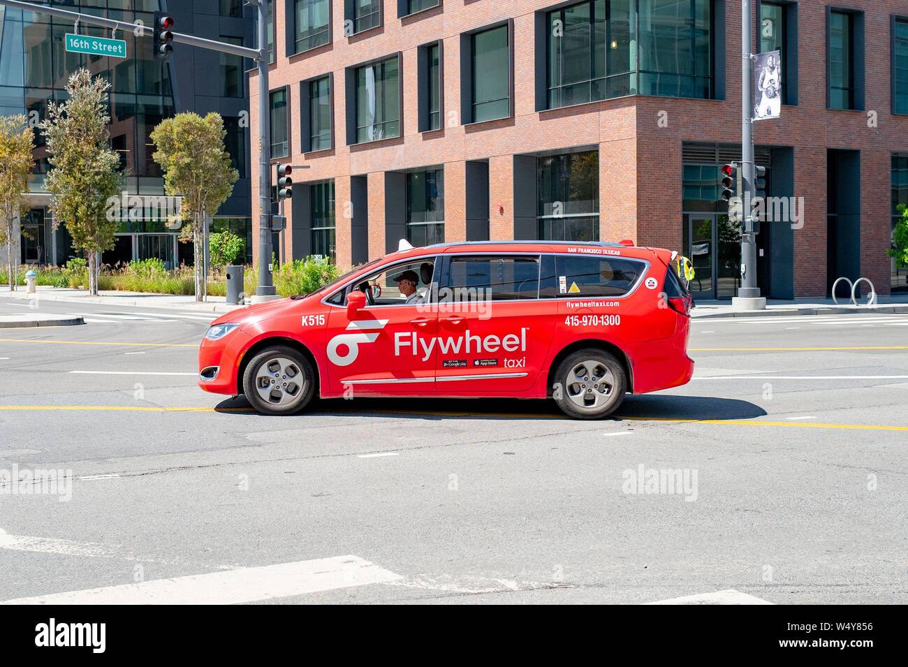 Side view of bright red taxi cab from appbased taxi service Flywheel in the Mission Bay