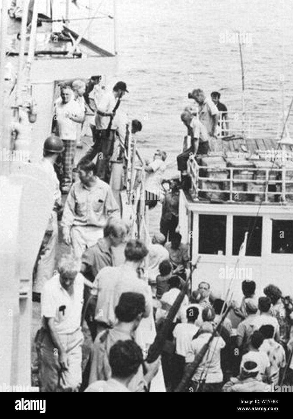 Crew of SS Mayaguez is transferred from a Thai fishing boat to USS Henry B. Wilson (DDG-7) on 15 May 1975. Stock Photo
