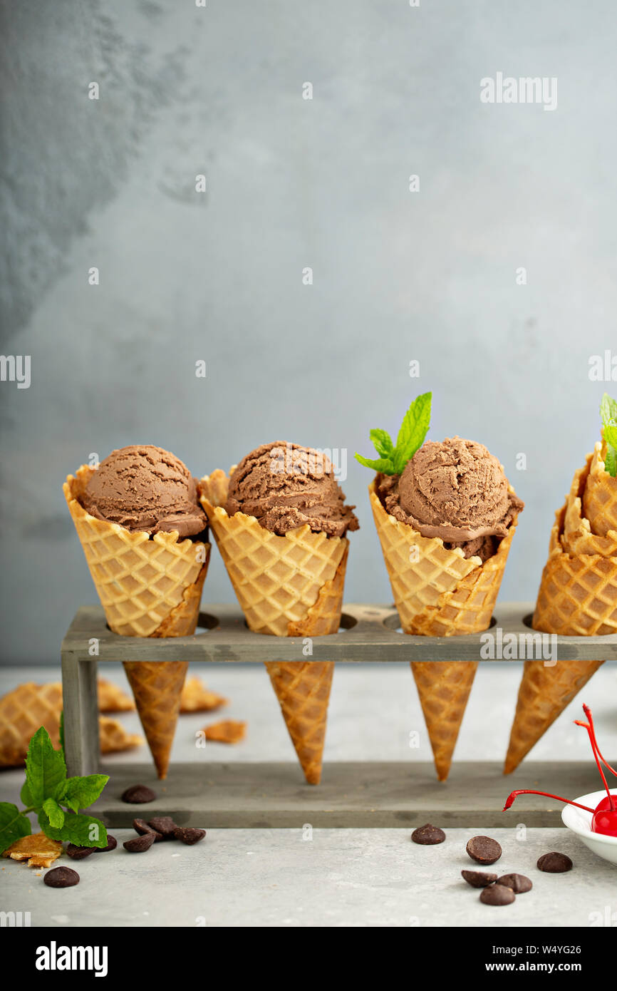 Chocolate ice cream in waffle cones with mint and cherries Stock Photo