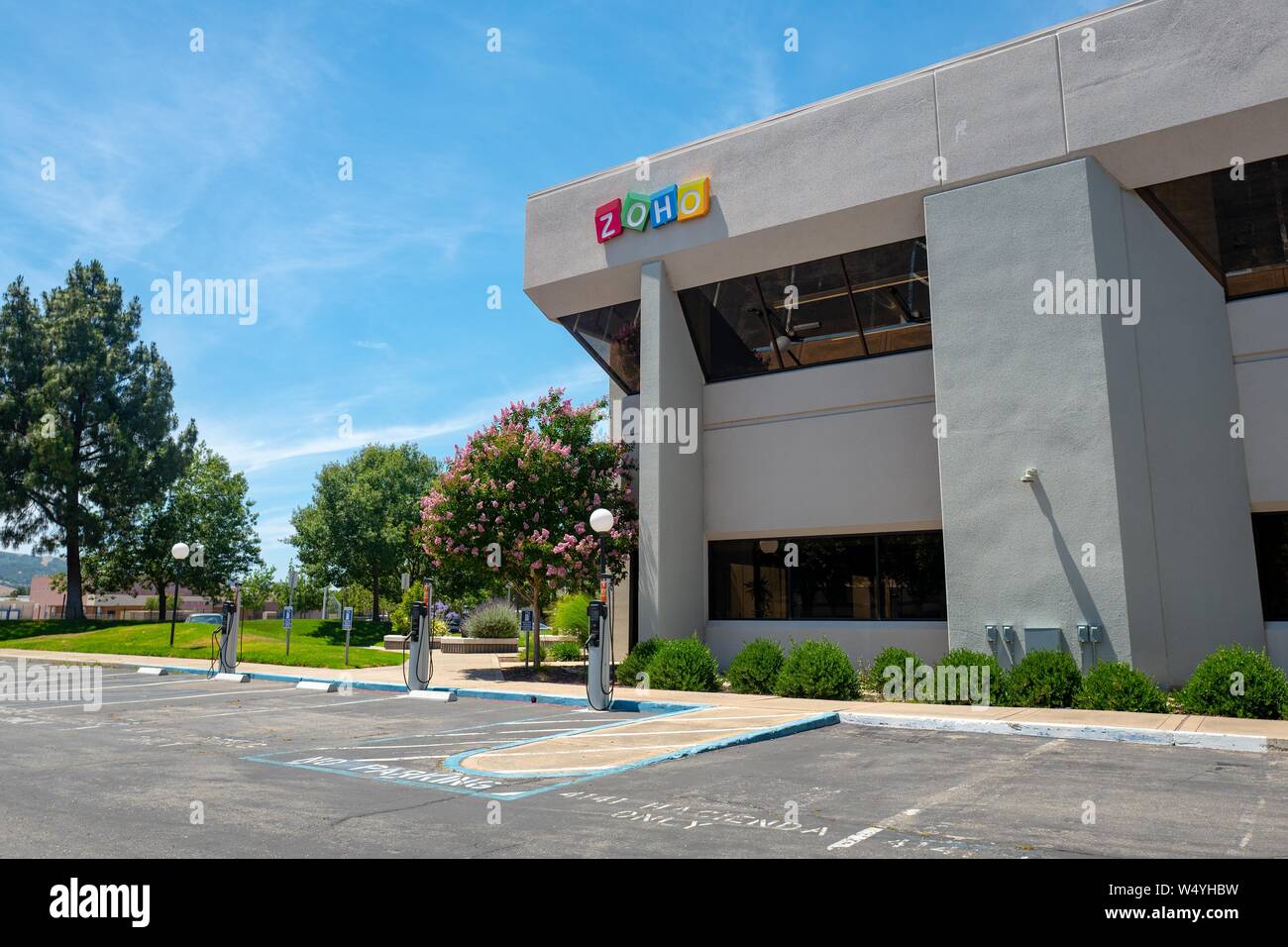 Facade with sign and logo at entrance to office of Customer Relationship Management (CRM) software company Zoho in Pleasanton, California, July 2, 2019. () Stock Photo