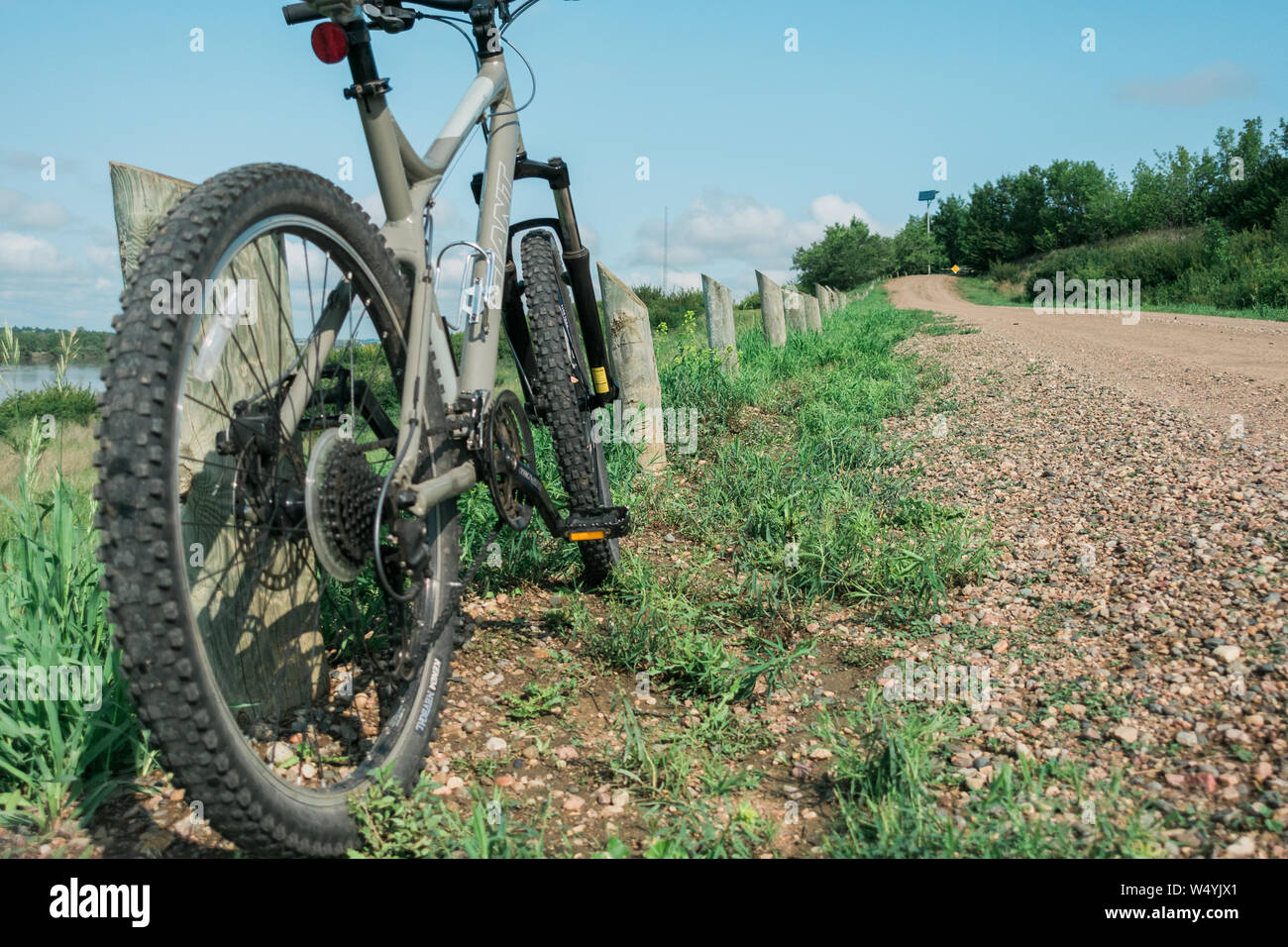 Bike on the dirt road leaning against a small post Stock Photo