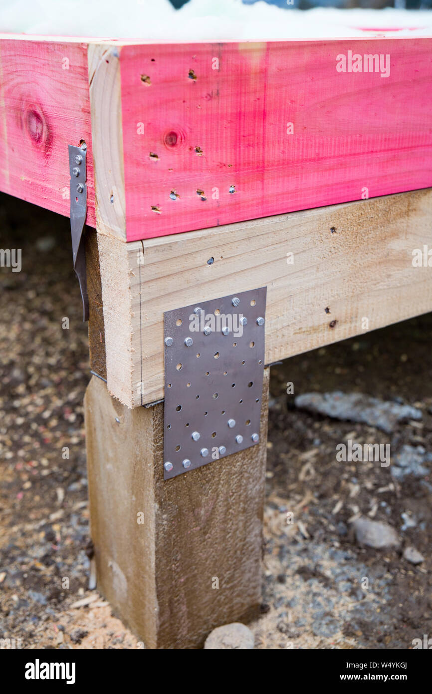 A gang-nail joint connecting the timber framing to the wooden piles on a new house's foundations on a building site in New Zealand Stock Photo