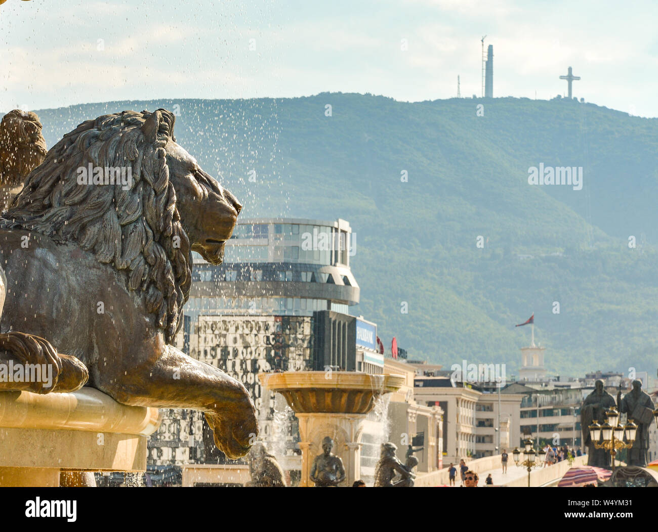 SKOPJE,REPUBLIC OF NORTH MACEDONIA-AUGUST 25 2018:Millennium Cross (background) overlooks the Statues and fountains at the Place next tothe Museum of Stock Photo