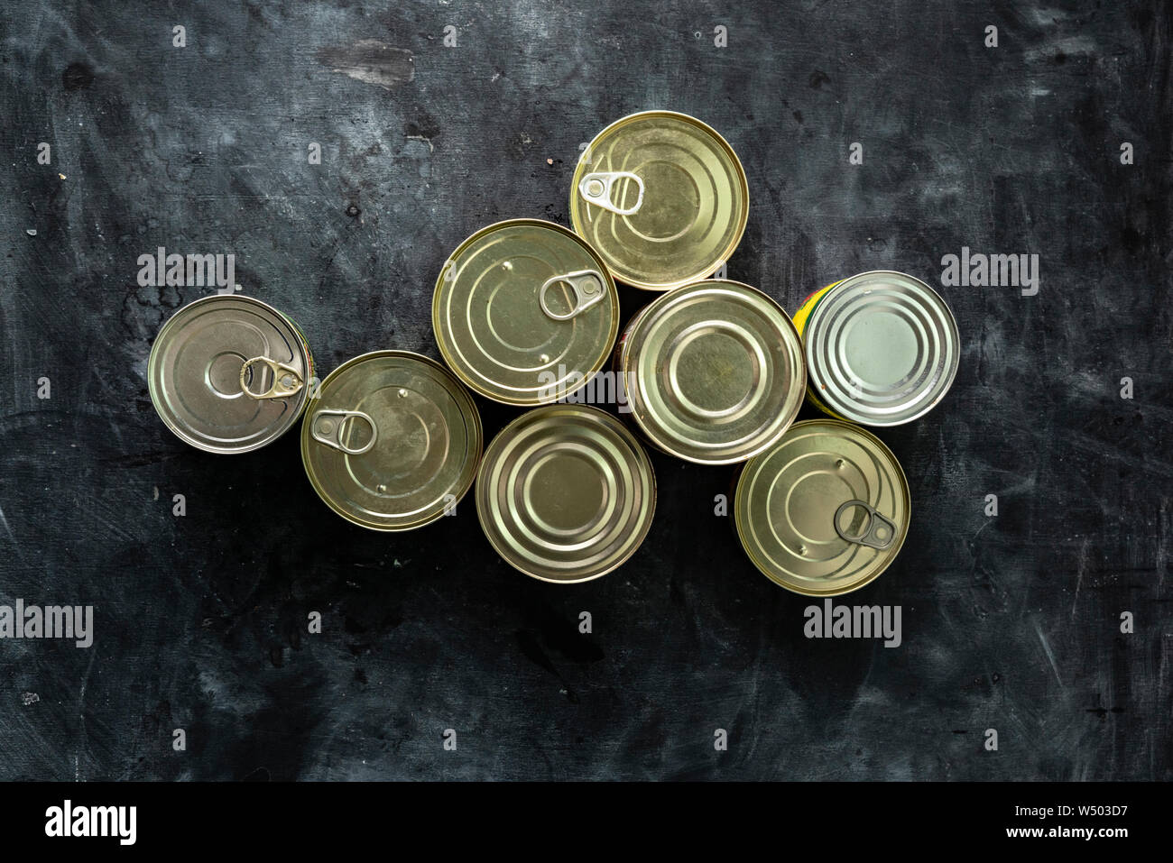 Unopened Food many unopened tin cans with meals such as meat and fish on the table ...