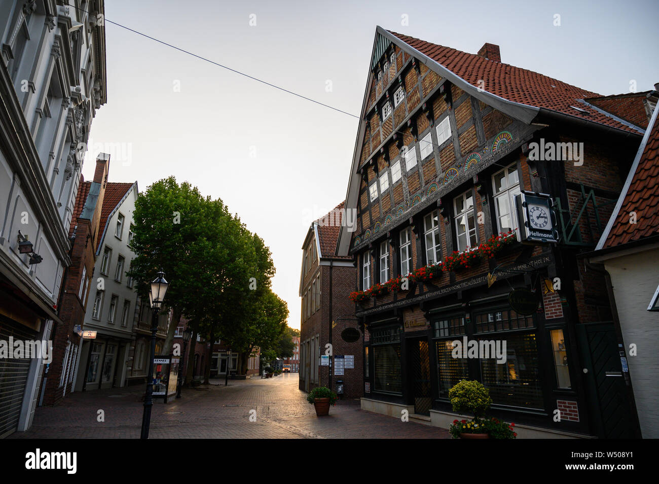 Lingen, Germany. 26th July, 2019. The rising sun shines through a street  with a half-timbered house. Lingen in Lower Saxony was the hottest place in  Germany on 25.07.2019 with 42.6 degrees according