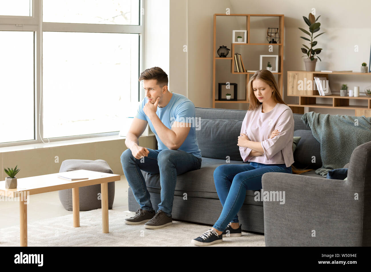 Young offended couple after quarrel sitting on sofa at home Stock Photo ...