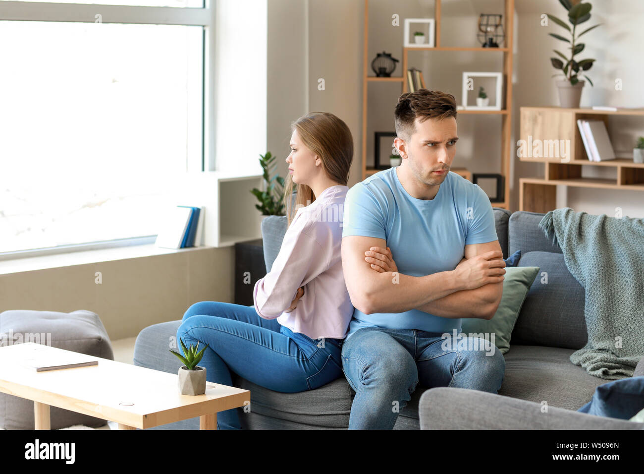 Young offended couple after quarrel sitting on sofa at home Stock Photo ...