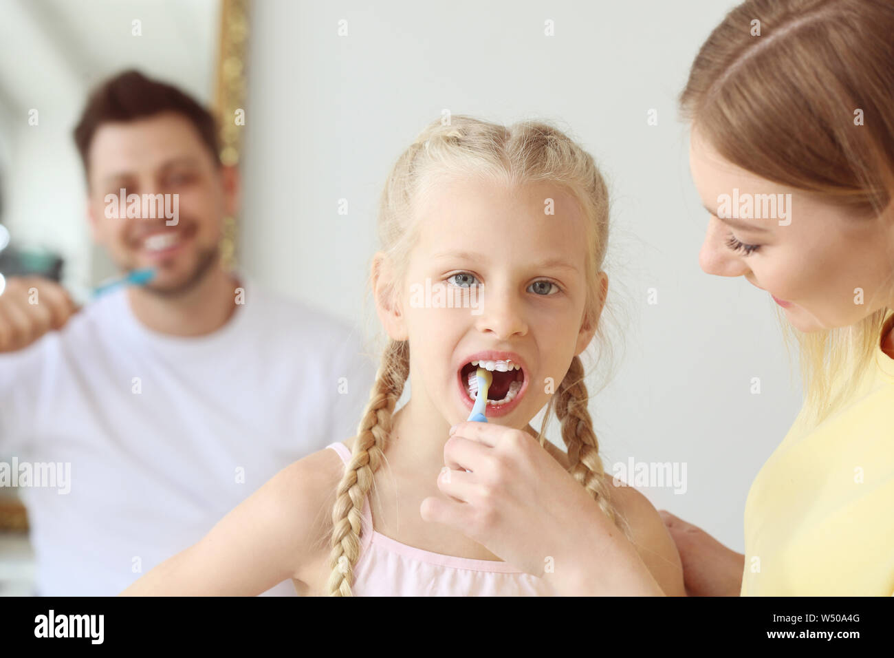 Mother teaching little girl to clean teeth at home Stock Photo Alamy