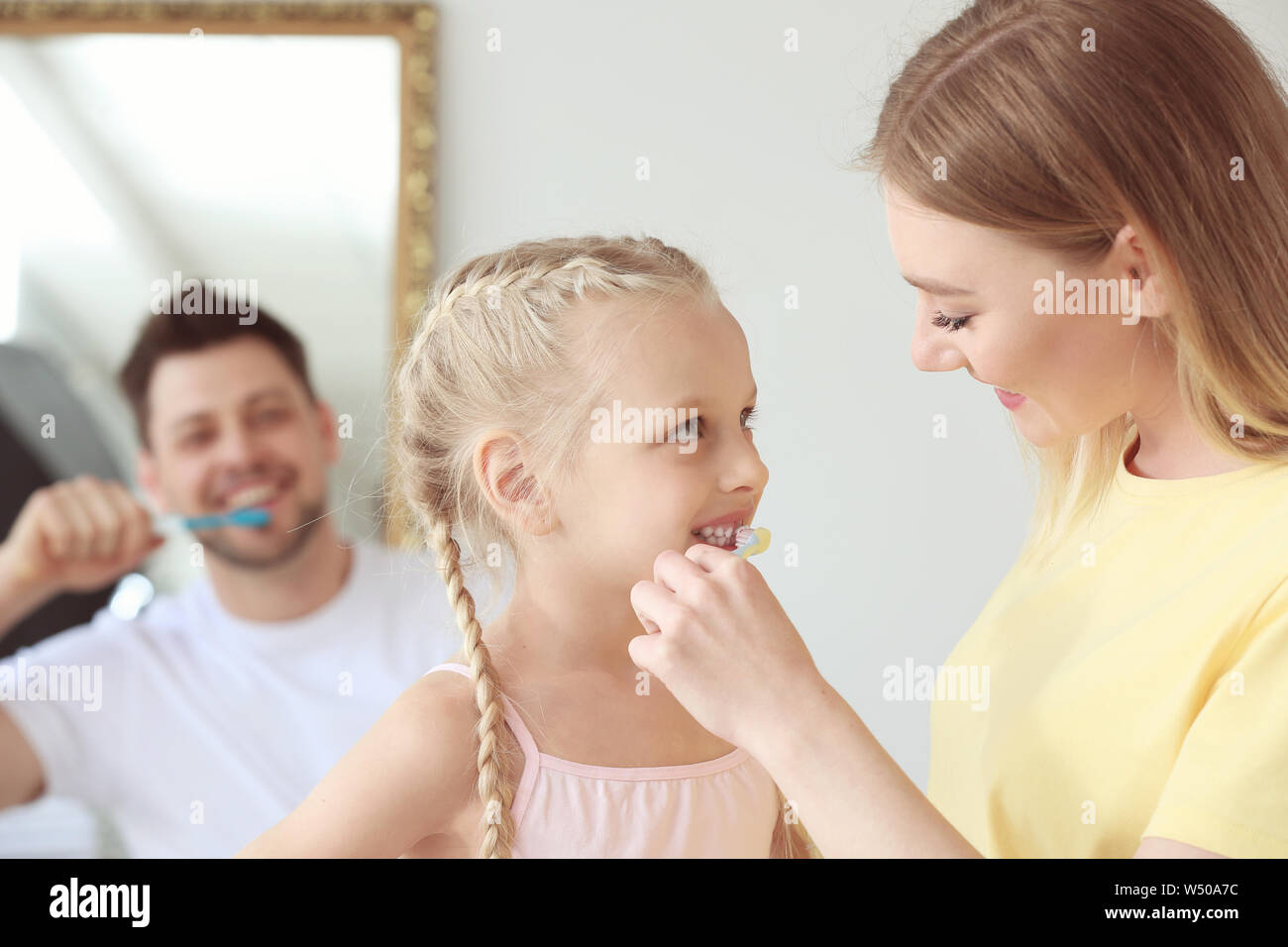 Mother teaching little girl to clean teeth at home Stock Photo Alamy
