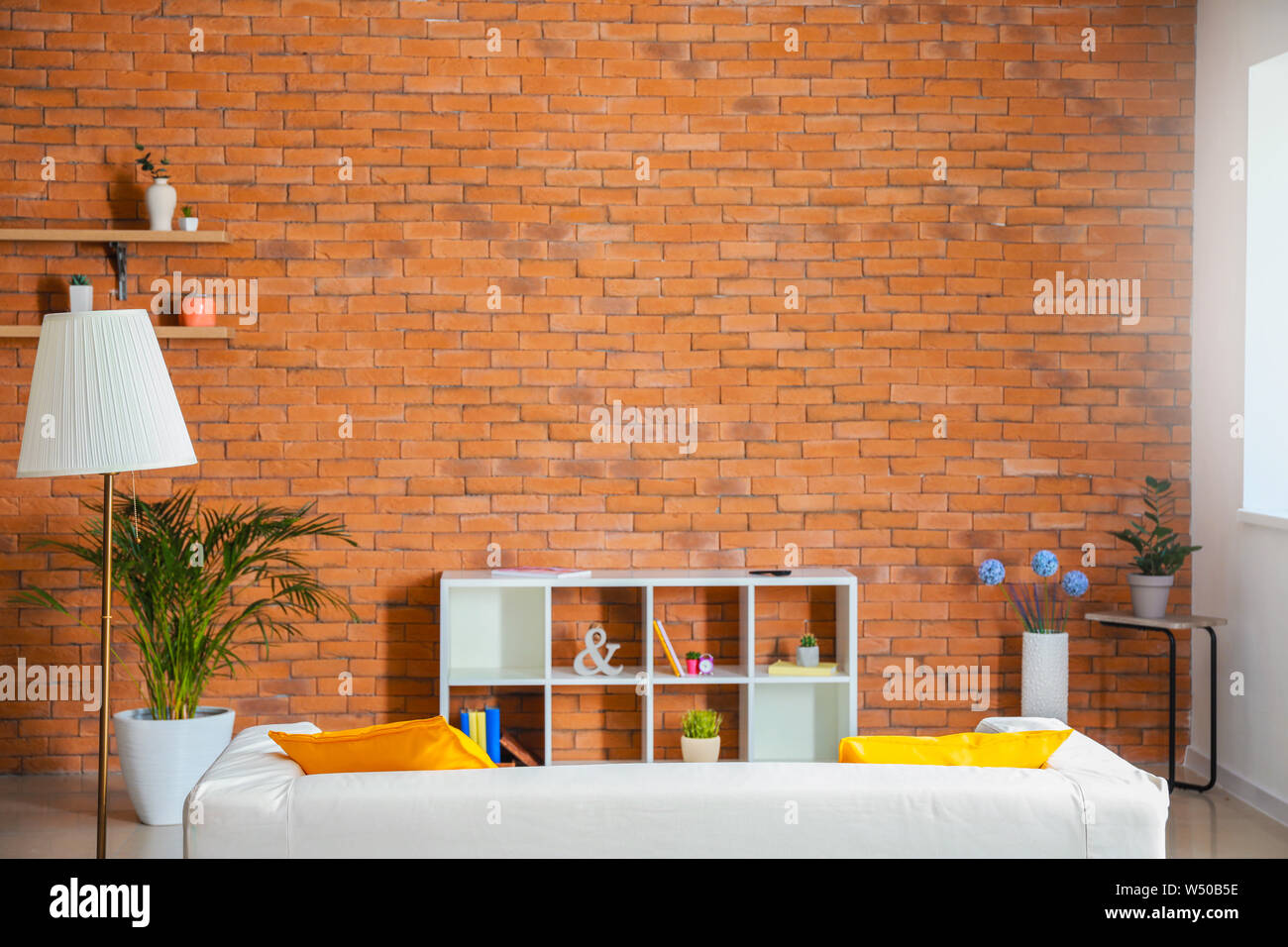 Stylish interior of modern living room with brick wall Stock Photo - Alamy