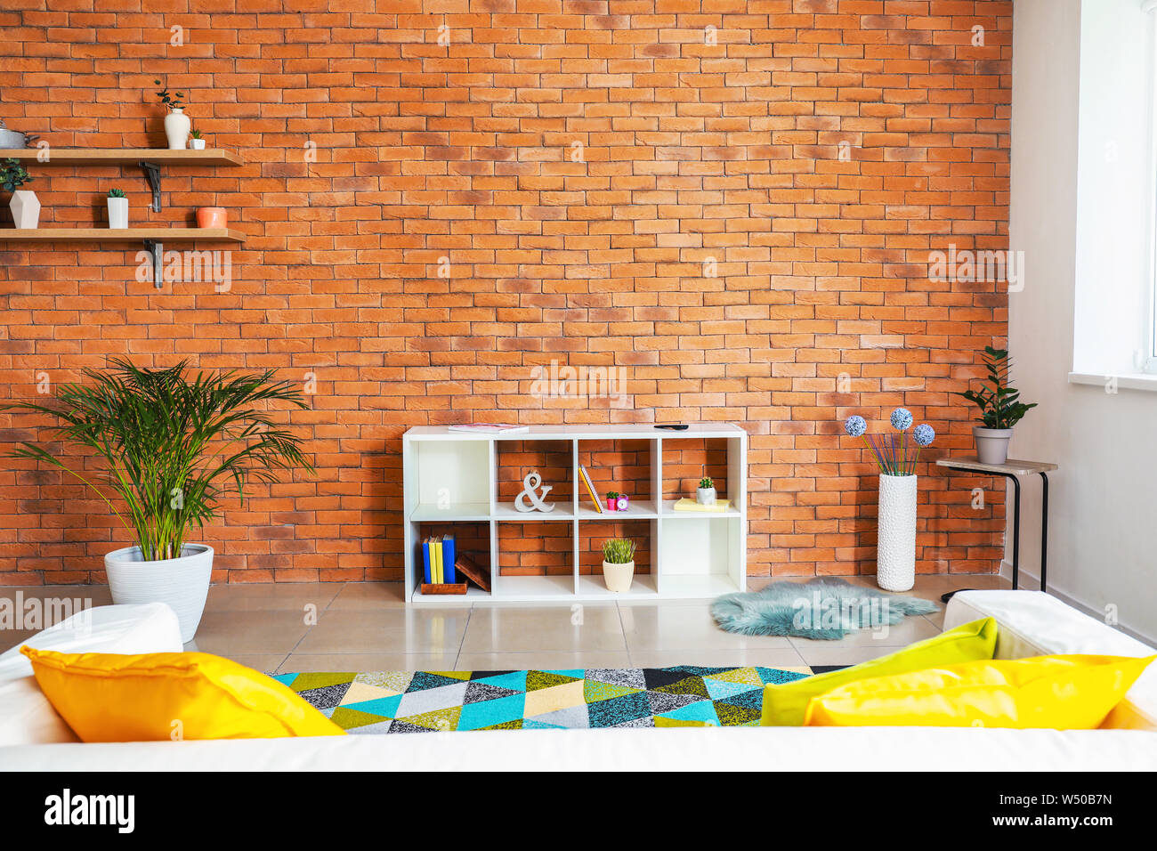 Stylish interior of modern living room with brick wall Stock Photo - Alamy