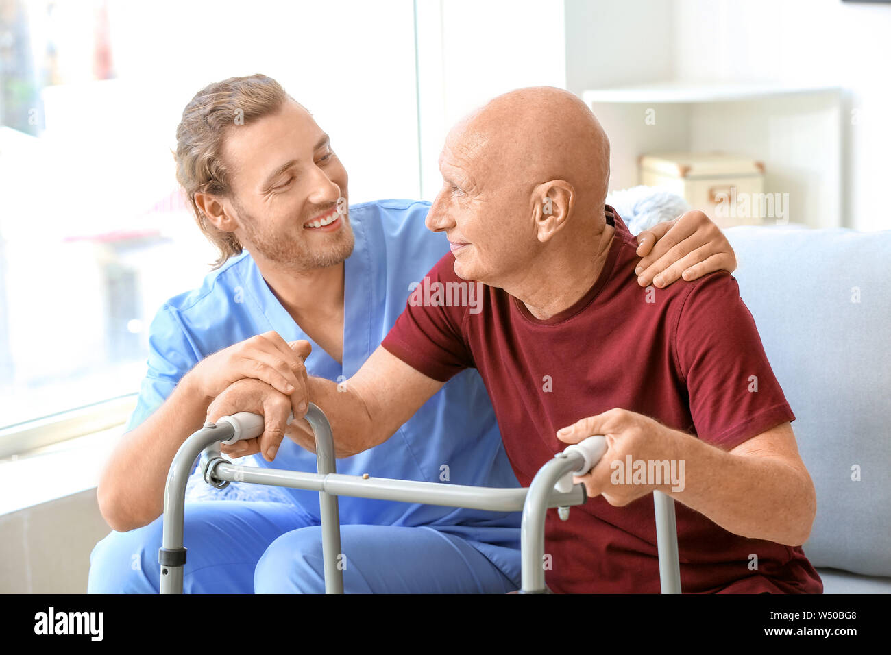 Elderly man with caregiver in nursing home Stock Photo - Alamy