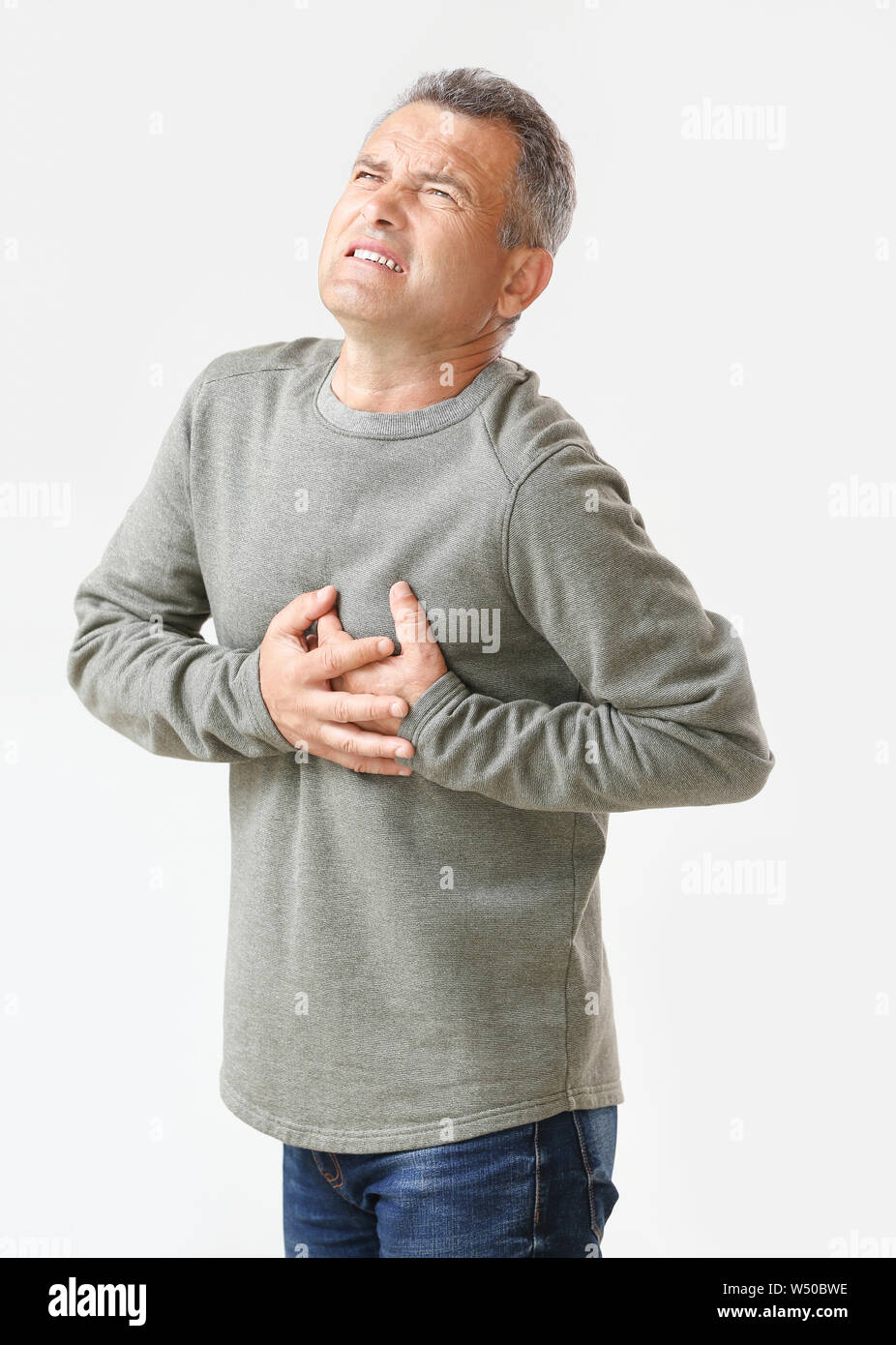 Mature man suffering from heart attack on white background Stock Photo ...