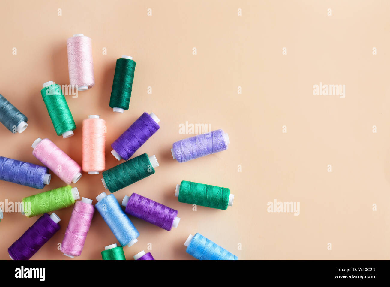 Many sewing threads on color background Stock Photo