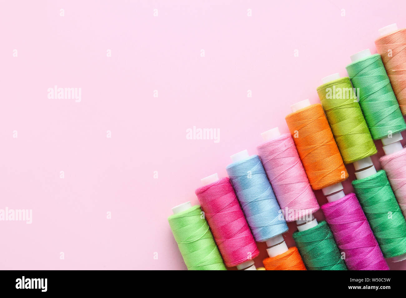 Many sewing threads on color background Stock Photo
