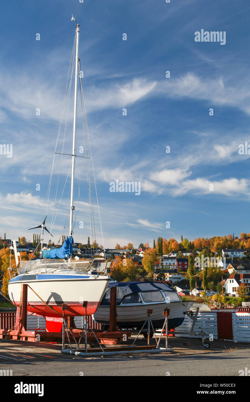 Motorboat and sailing yachts stand on the coast in Norwegian port at sunny autumn day. Levanger, Norway Stock Photo