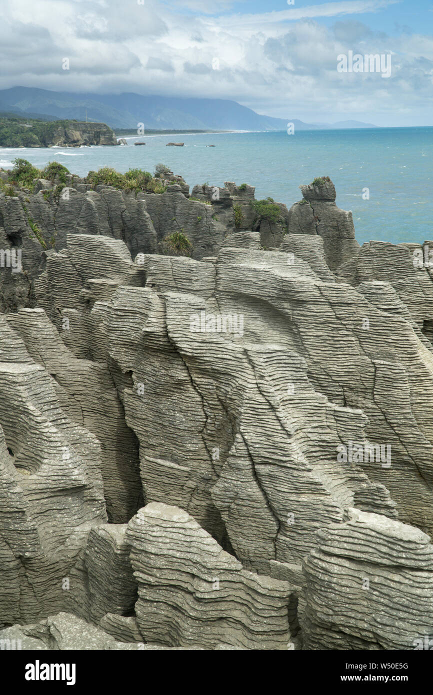 Bedding in Oligocene-age limestone and Tasman Sea at Punakaiki, New Zealand --Pancake Rocks. Stock Photo