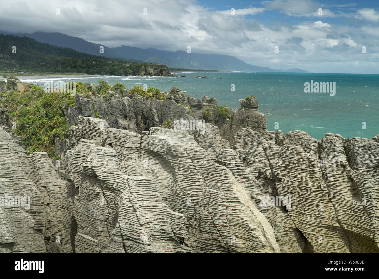 Bedding in Oligocene-age limestone and Tasman Sea at Punakaiki, New Zealand --Pancake Rocks. Stock Photo