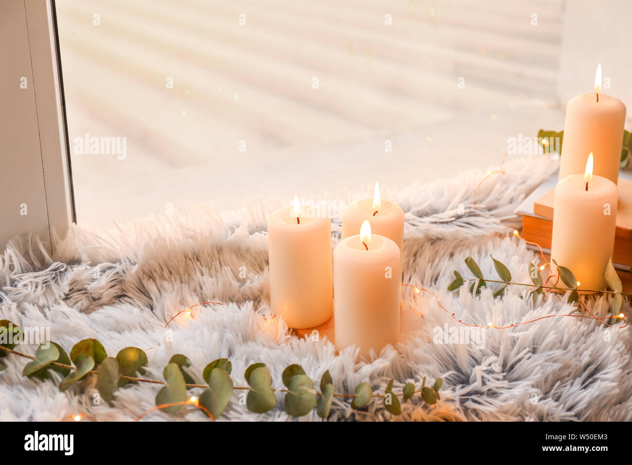 Beautiful burning candles on window sill Stock Photo Alamy