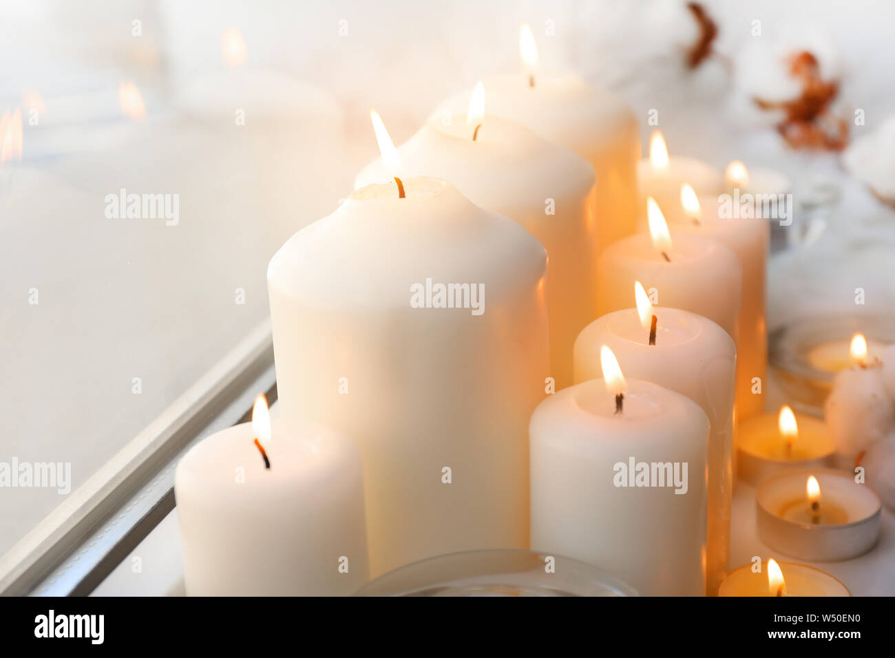 Beautiful burning candles on window sill Stock Photo - Alamy