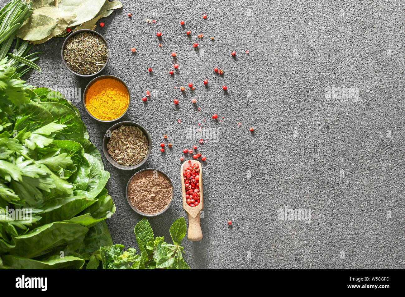 Different herbs and spices on grey background Stock Photo