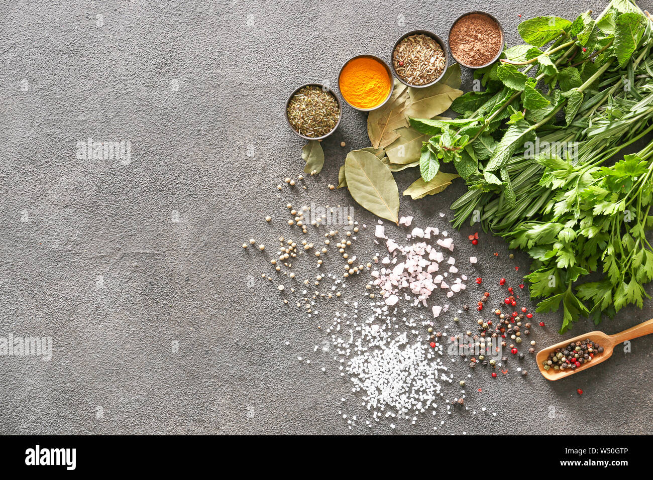 Different herbs, salt and spices on grey background Stock Photo - Alamy