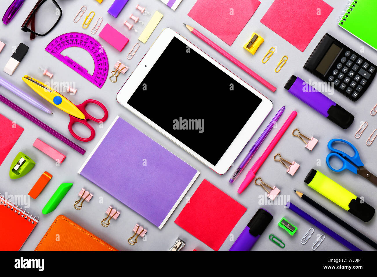 Modern tablet computer with stationery on grey background Stock Photo