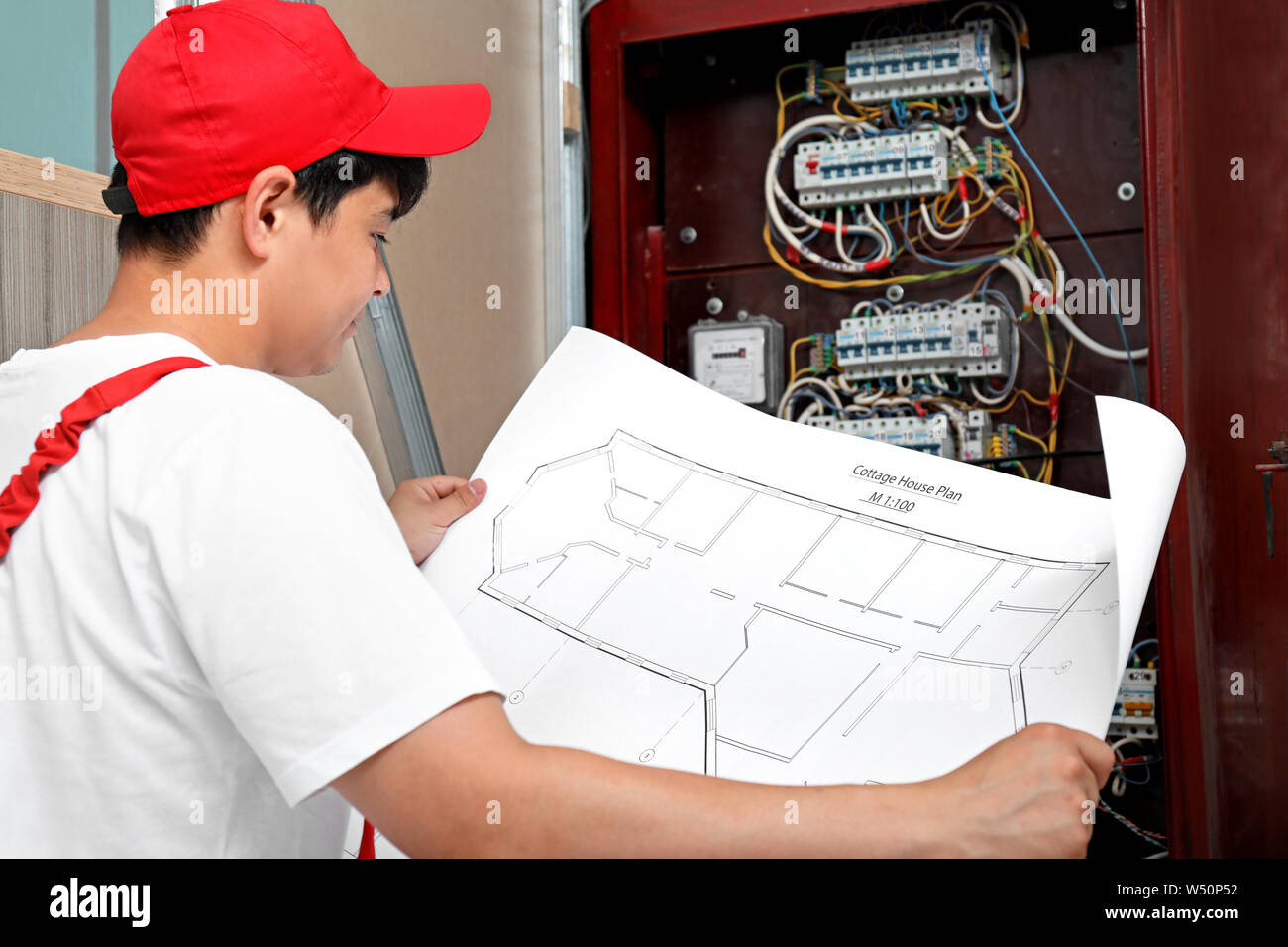 Electrician with wiring diagram indoors Stock Photo Alamy