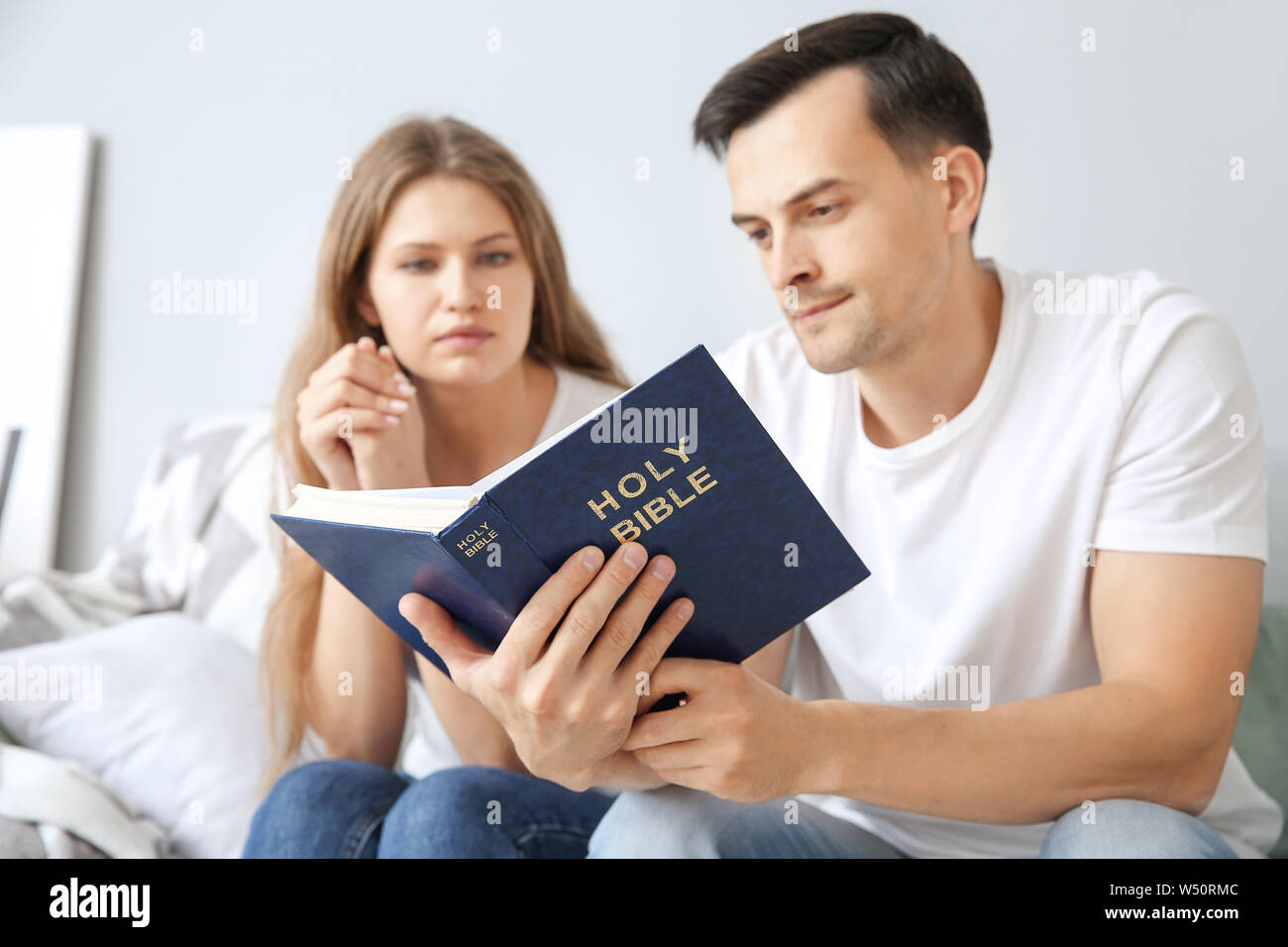 Religious couple reading Bible at home Stock Photo Alamy