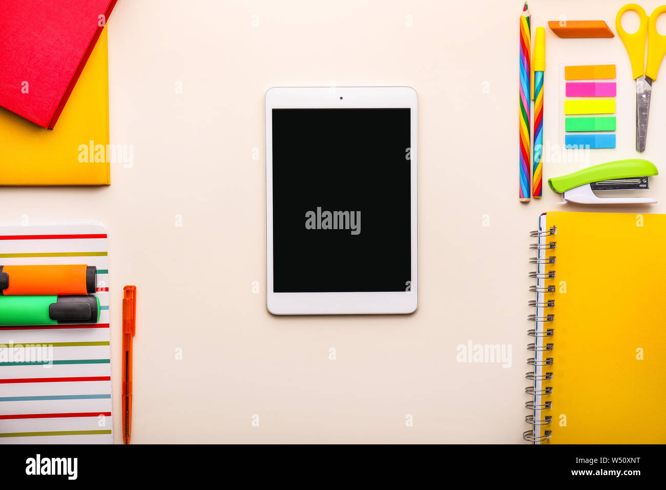 Modern tablet computer and school supplies on light background Stock Photo