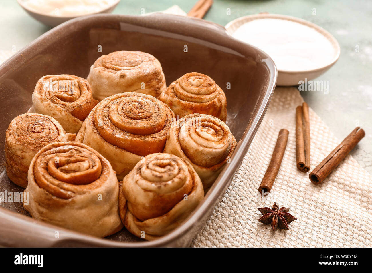 Baking tray with tasty cinnamon buns on table Stock Photo