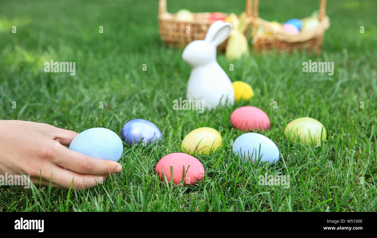 Woman gathering Easter eggs outdoors Stock Photo