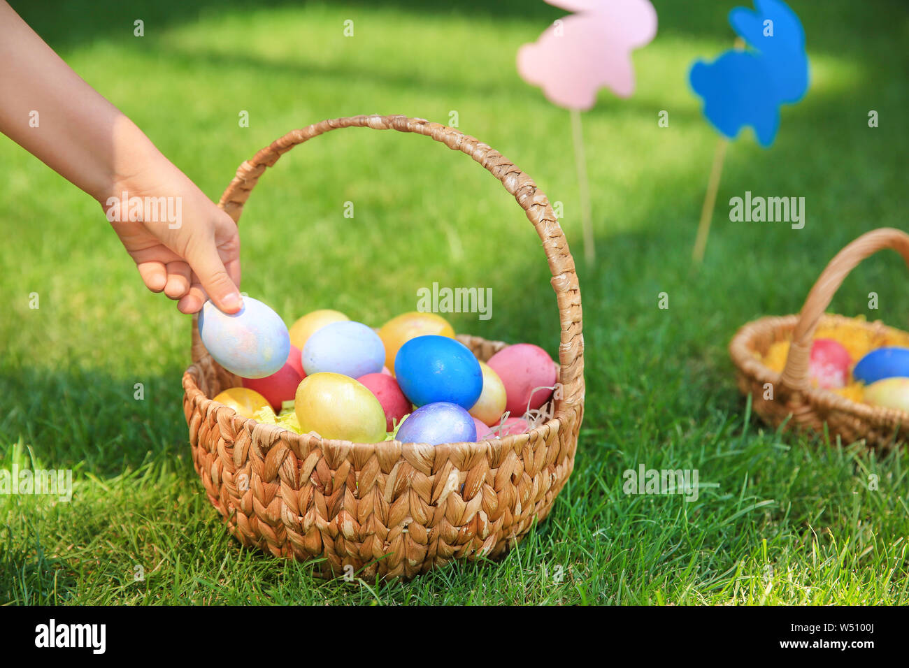 Woman gathering Easter eggs outdoors Stock Photo