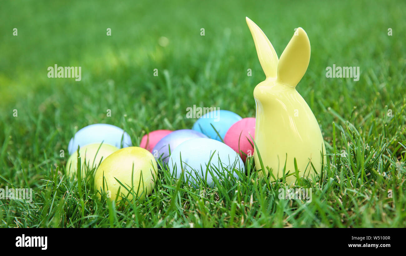 Easter eggs with ceramic bunny on grass outdoors Stock Photo - Alamy