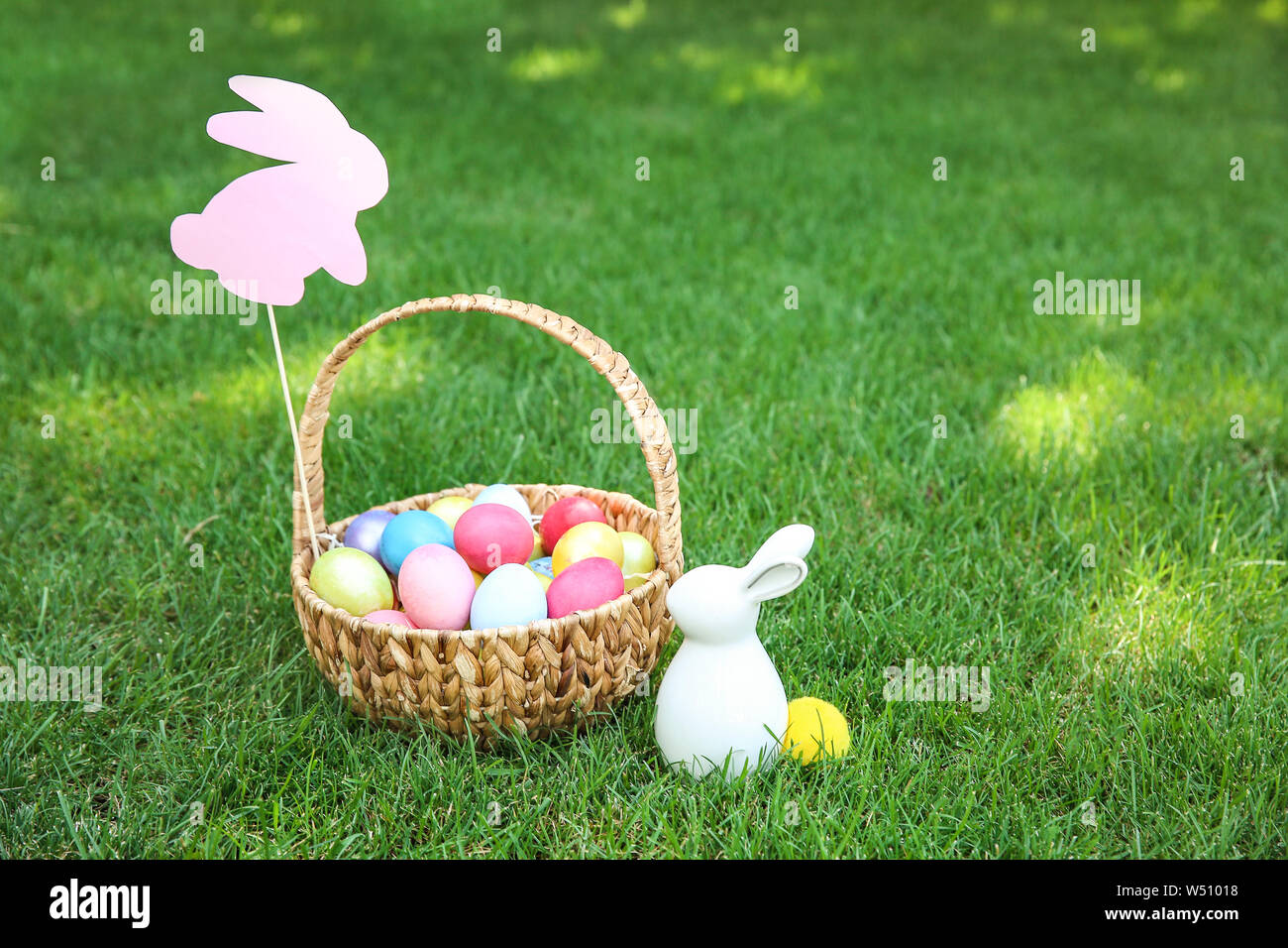 Basket with Easter eggs and bunny on grass outdoors Stock Photo - Alamy