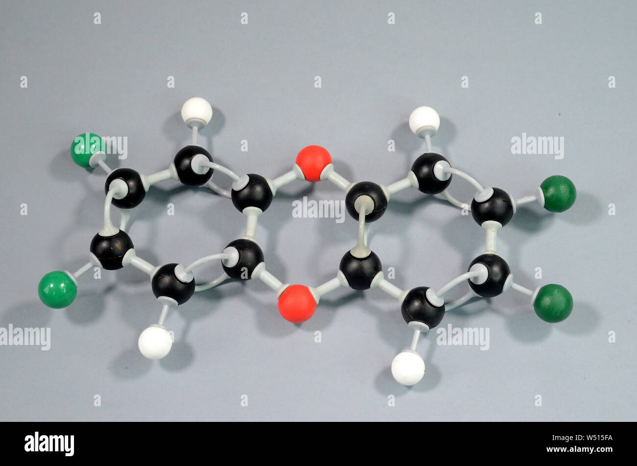 Molecule model of Dioxine. Black is Carbon, red is Oxygen, green is Chlorine, white is Hydrogen Stock Photo