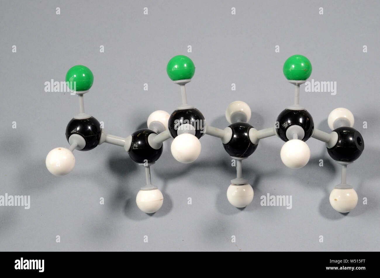 Molecule model of a part of a PVC string. Black is Carbon, green is Chlorine, white is Hydrogen Stock Photo