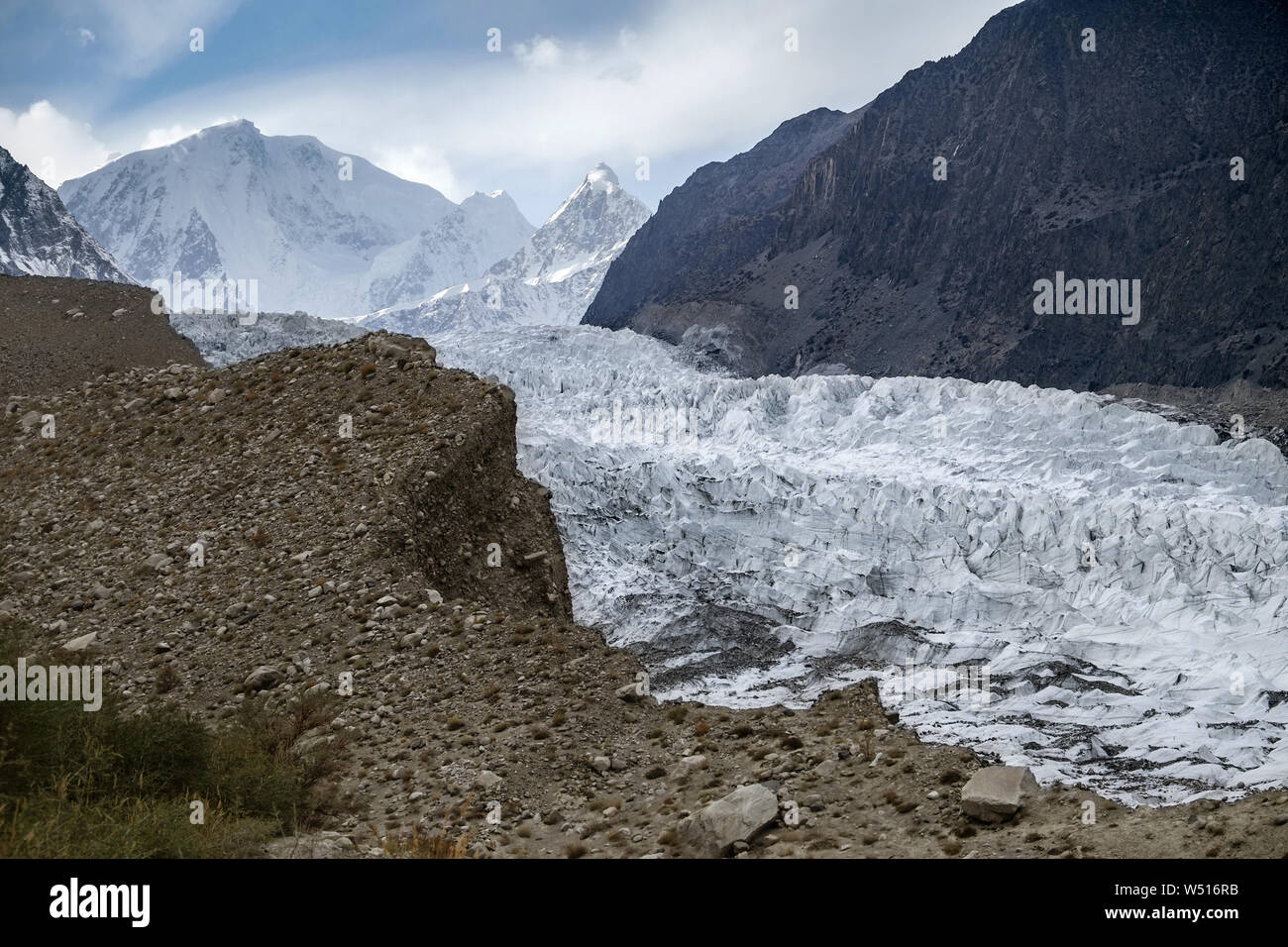 Beautiful landscape scenery of white Passu Glacier against snow capped mountains in Karakoram range with fog and clouds, Gojal Hunza. Gilgit Baltistan Stock Photo