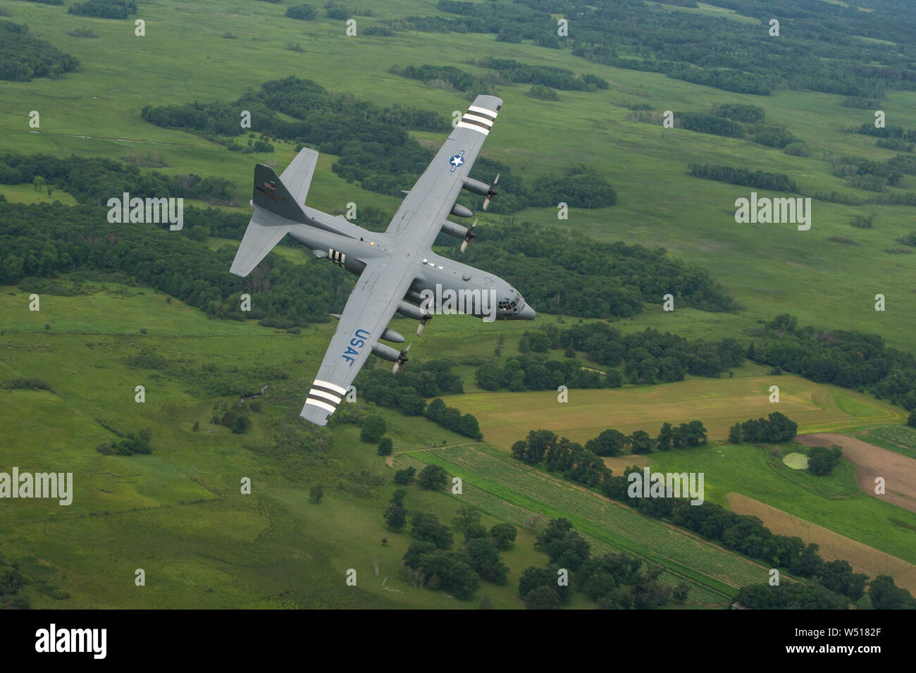 A U.S. Air Force C-130H Hercules aircraft from the 96th Airlift Squadron, Minneapolis-St. Paul Air Reserve Station, Minn., flies over Minnesota, July 16, 2019. Aircraft number 23284 was painted with WWII invasion stripes in honor of the 75th anniversary of D-Day. Originally activated as the 96th Troop Carrier Squadron, the 96th, dropped paratroops of the 101st Airborne Division in Normandy during the D-Day invasion and flew numerous missions to bring in reinforcements and needed supplies during the war. (U.S. Air Force Photo by Tech. Sgt. Amber E. N. Kurka) Stock Photo