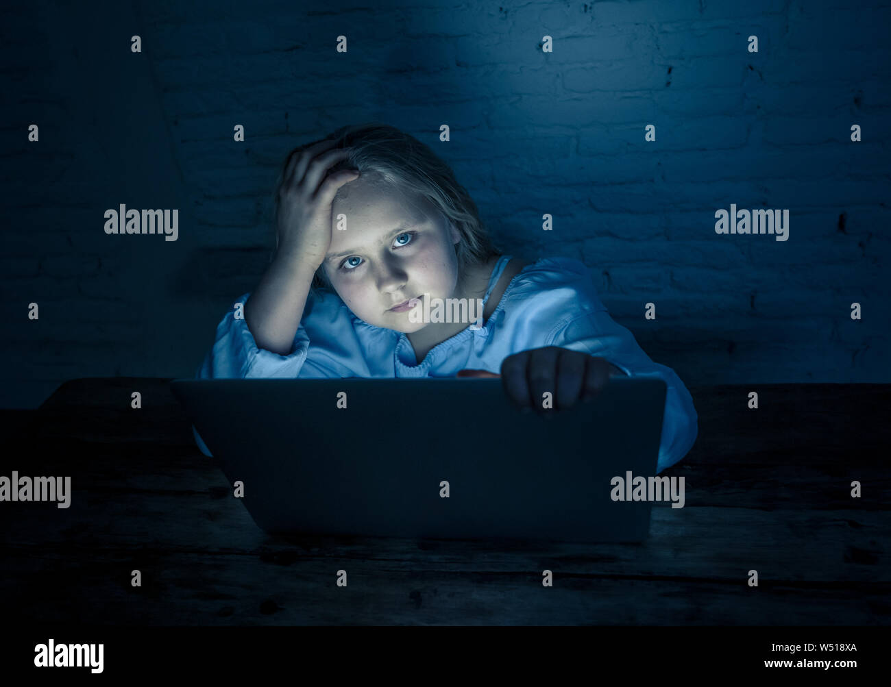 Scared sad girl bullied on line with laptop suffering cyber bullying harassment feeling desperate and intimidated. Child victim of bullying stalker so Stock Photo