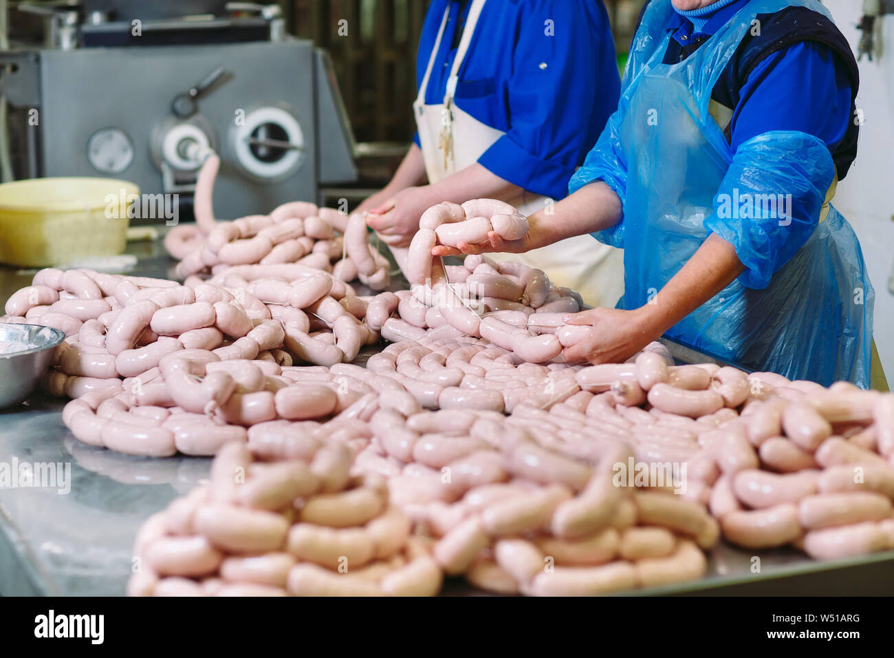 Butchers processing sausages at a meat factory Stock Photo Alamy