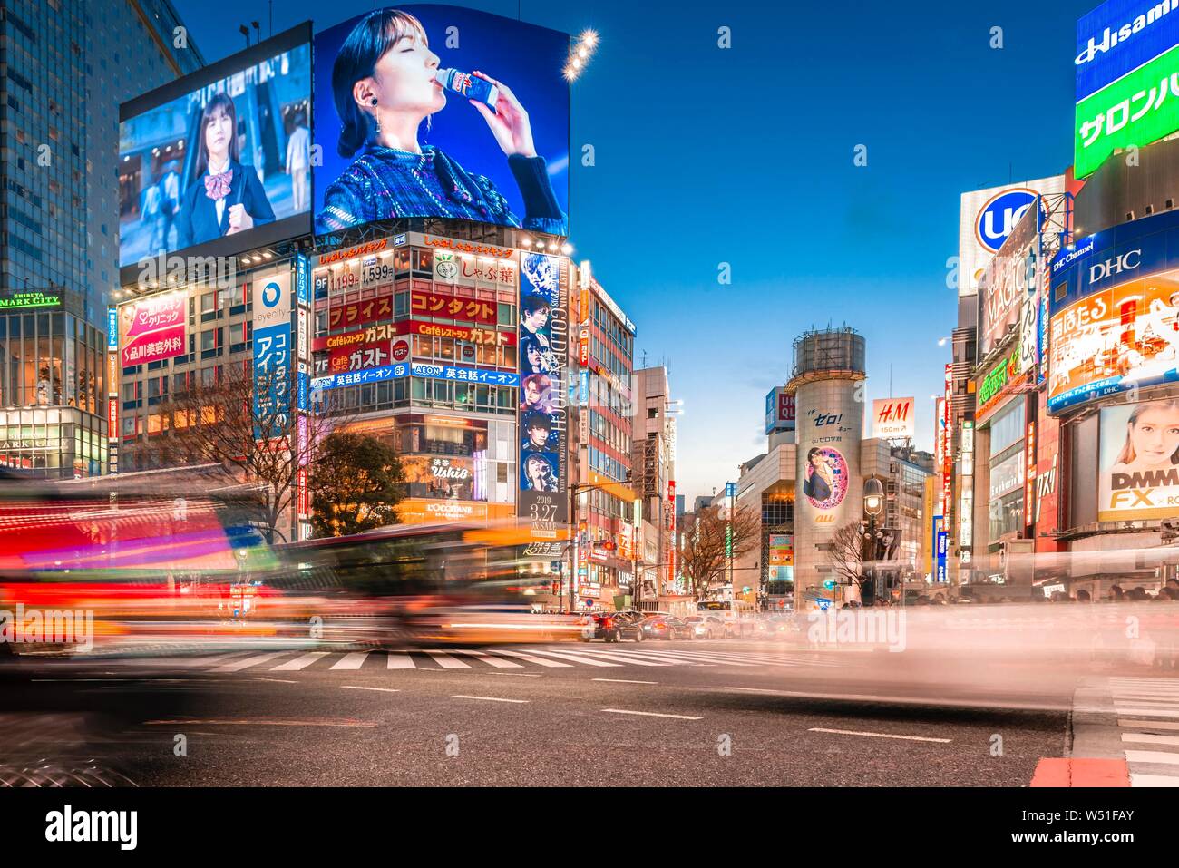 Shibuya Crossing, long exposure, cars crossing, colorful signs and neon signs at dusk, train station Shibuya, Shibuya, Udagawacho, Tokyo, Japan Stock Photo