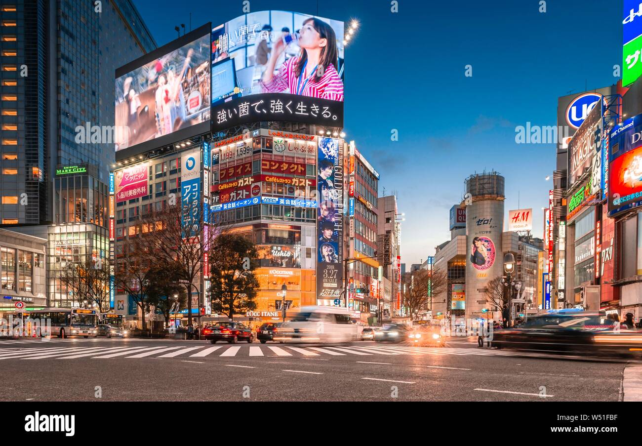 Shibuya Crossing, long exposure, cars crossing, colorful signs and neon signs at dusk, train station Shibuya, Shibuya, Udagawacho, Tokyo, Japan Stock Photo