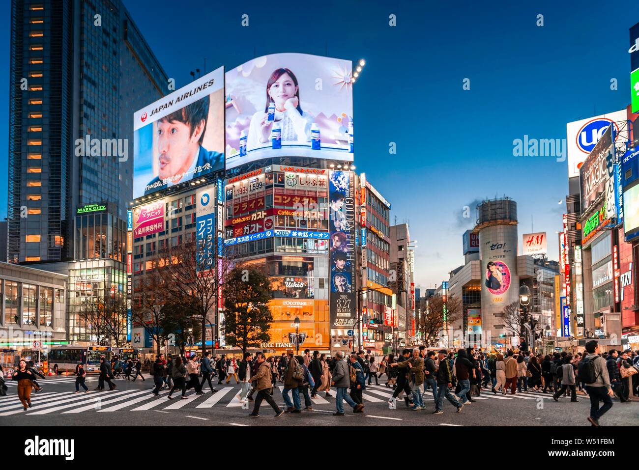 Shibuya Crossing, crowds at crossroads, colorful signs and illuminated advertising at dusk, railway station Shibuya, Shibuya, Udagawacho, Tokyo, Japan Stock Photo