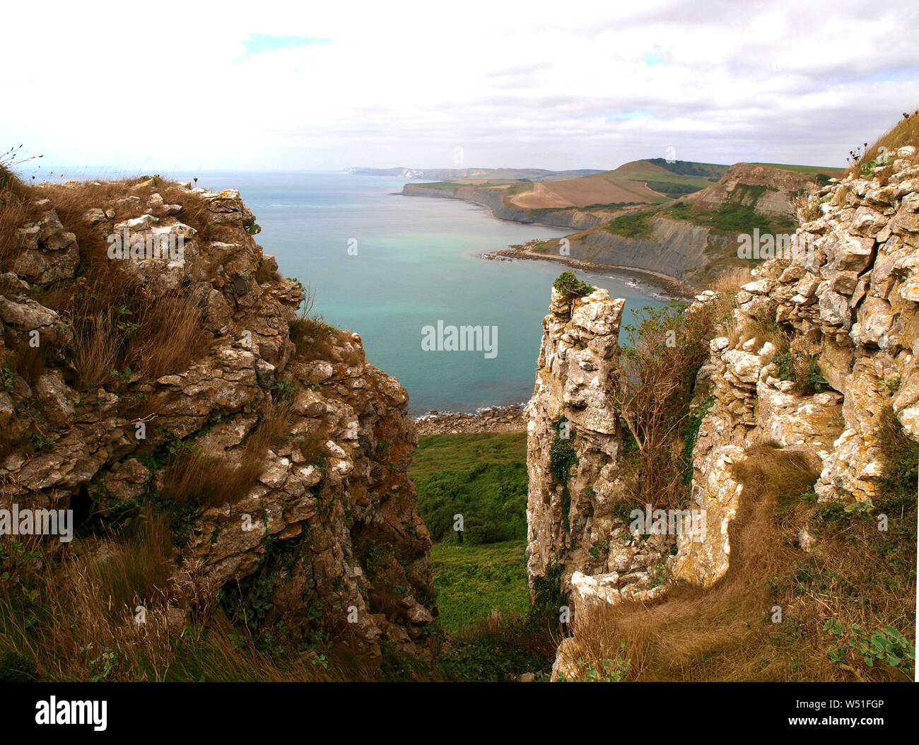 The view through the rocky outcrop from the cliff top above Chapmans Pool near Worth Matravers in Dorset, UK with the Jurassic coastline in the backgr Stock Photo