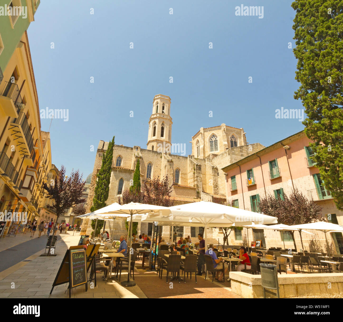 FIGUERES, SPAIN - JUNE 14: Tourist on Main square, Figueres, Spain. Tourists in the church square in Figueres. In the background, the Dali Museum Stock Photo