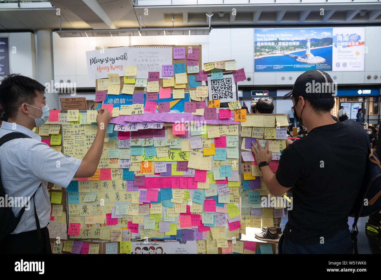 Demonstrators put sticky note on a pop up Lennon wall during the protest at the airport arrival hall.Hundreds of anti government protesters staged a sit in protest at the Hong Kong international airport terminal, the first of three straight days of demonstrations after clashes last week triggered fears that a wider confrontation could erupt in the city. Stock Photo