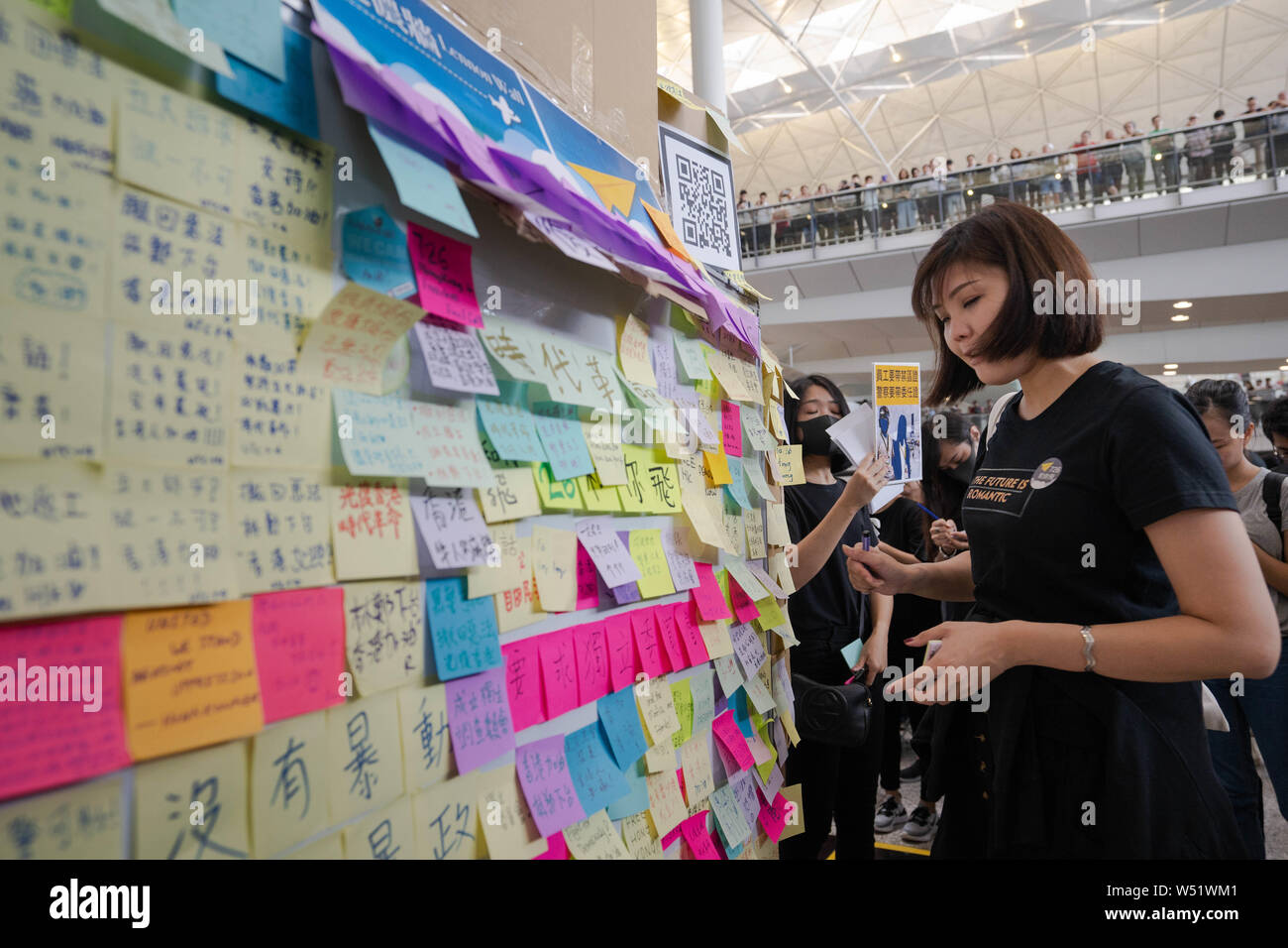 A demonstrator put a sticky note with messages written on it on a pop up Lennon wall during the protest at the airport arrival hall.Hundreds of anti government protesters staged a sit in protest at the Hong Kong international airport terminal, the first of three straight days of demonstrations after clashes last week triggered fears that a wider confrontation could erupt in the city. Stock Photo
